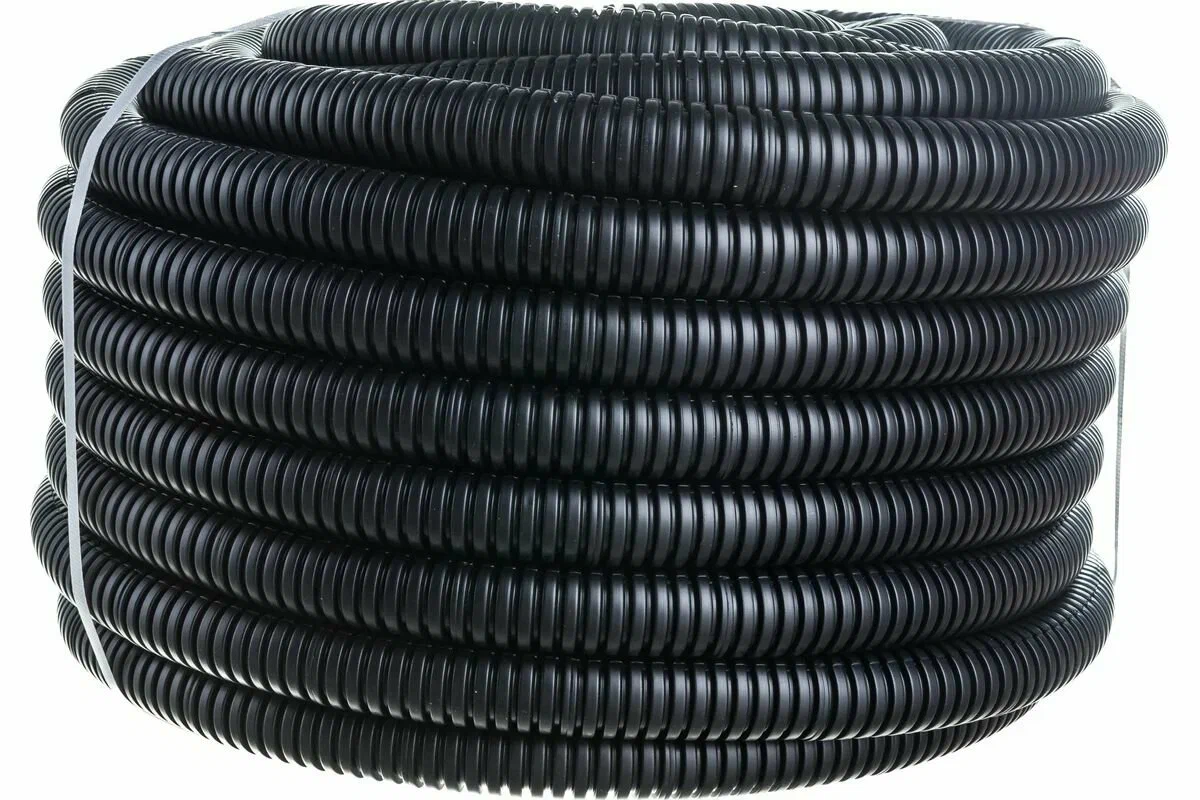 Черный гофрированный шланг, скрученный в бухту. Электрическая гофра для проводки.
