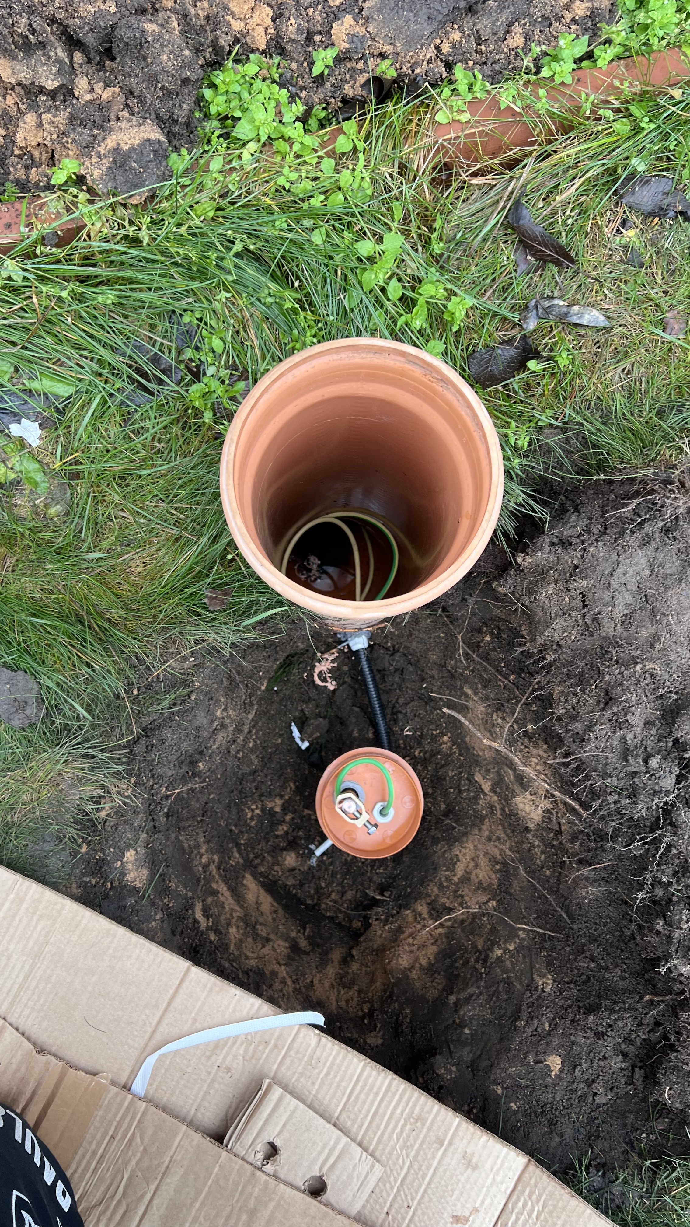 Заземление в частном доме: пластиковая труба в земле с проводами